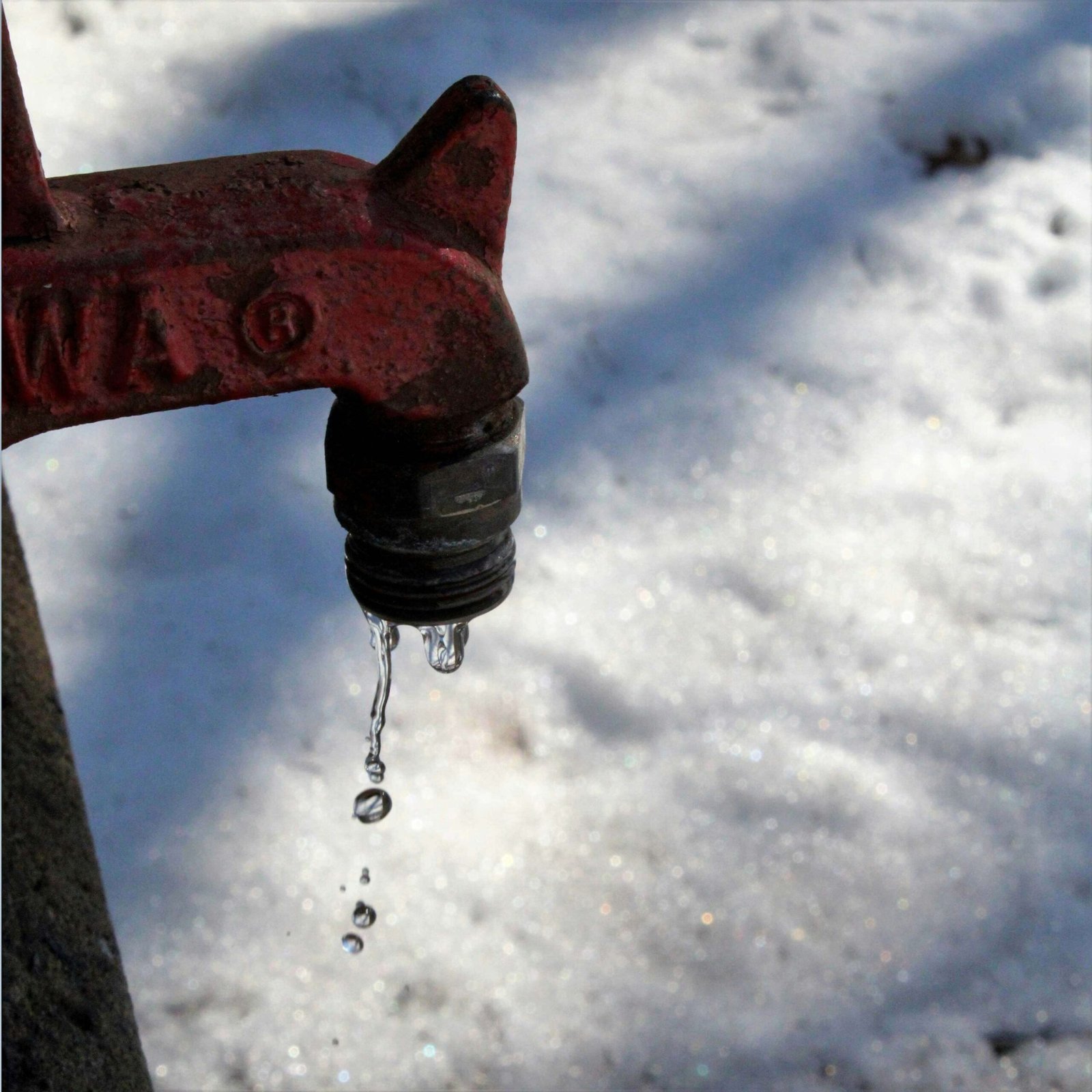 Running outside faucet with water in the snow.